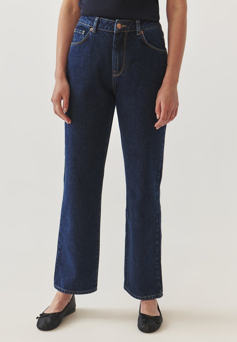 Jeans de mezclilla de corte amplio en azul oscuro, con una cintura alta, cinco bolsillos, costuras de contraste y cierre de botón.