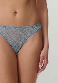 Lichtblauwe kanten string met een intricate bloemenpatroon, voorzien van een soepele tailleband en transparante mesh zijkanten voor een delicate uitstraling.