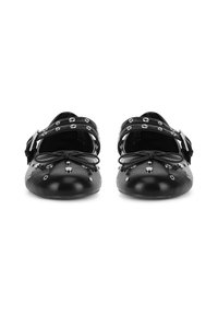 Czarne skórzane baleriny z zaokrąglonym noskiem, ozdobione srebrnymi ćwiekami i paskami. Posiadają kokardę z przodu oraz zapięcie na klamrę.