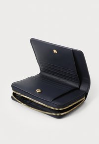Navy leather wallet with gold zipper and snap closure. Features multiple card slots and a smooth texture. Compact rectangular shape.