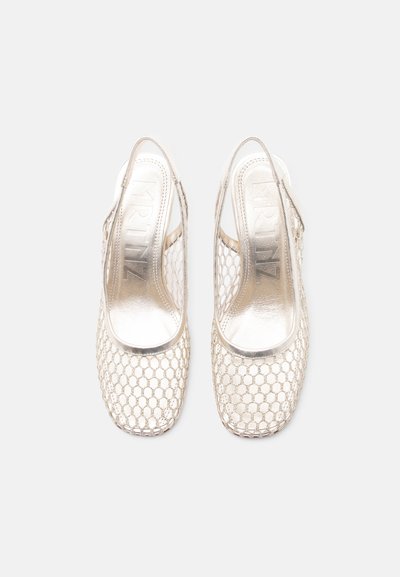 Ζευγάρι μεταλλικά χρυσά παπούτσια slingback με πλέγμα σε σχέδιο κυψελών και τετράγωνα δάχτυλα, φαίνεται από πάνω σε λευκό φόντο.