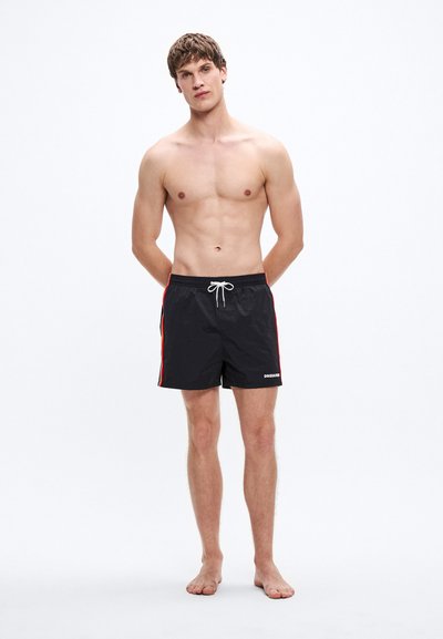 Pantaloni scurți de baie negri cu dungi laterale roșii, talie elastică și șnur. Materialul pare ușor și rezistent la apă.