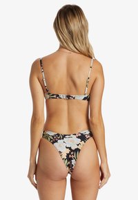 Kwiatowy bikini z cienkimi regulowanymi ramiączkami, na czarnym tle z dużymi pastelowymi kwiatami. Posiada zapięcie z tyłu.
