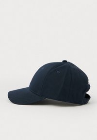 Sötétkék baseballsapka, amely textilből készült, ívelt karimával, hatszögletű kialakítással és hímzett logóval az elején.