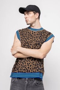 Kootud kampsun, millel on leopardimuster pruunil taustal, sinised ja rohelised triibud kaeluses ja äärtes, ning toorest servad.