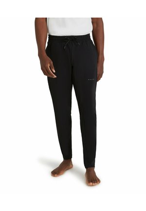 Zwarte sportbroeken met een elastische tailleband en een trekkoord. Voorzien van een slim fit en subtiele "FALKE" branding op het onderbeen.