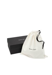 Schwarze rechteckige Massimo Dutti Box neben einem weißen Stoffbeutel mit schwarzem Kordelzug und Massimo Dutti Logo auf der Vorderseite.