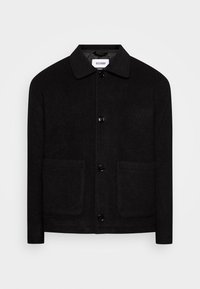 Giacca nera con colletto realizzata in tessuto morbido, dotata di due tasche anteriori, chiusura a bottoni e una leggera texture. Design minimalista e moderno.