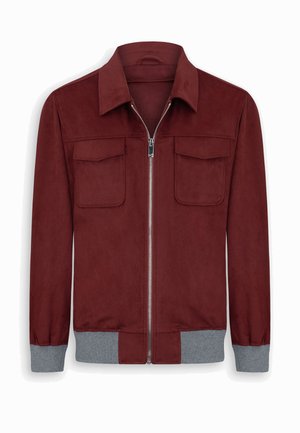 Viininpunainen vetoketjullinen takki, jossa on kaksi etutaskua läpällä, harmaat resorit hihansuissa ja harmaa resorivyötärö, valkoisella taustalla esillä.