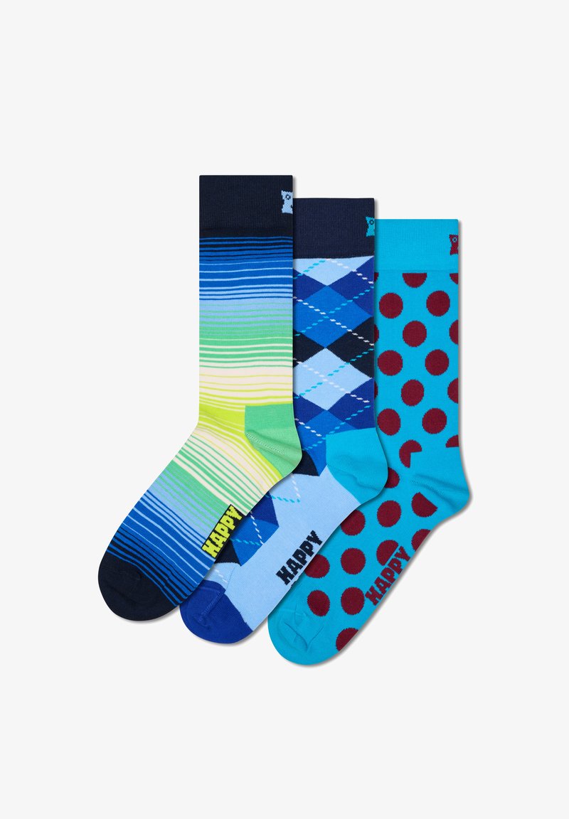 Drei Paar Socken: gestreift in Grün und Blau, Argyle in Blau mit weißen Akzenten und türkis mit roten Punkten. Das Material ist weiche Baumwolle.