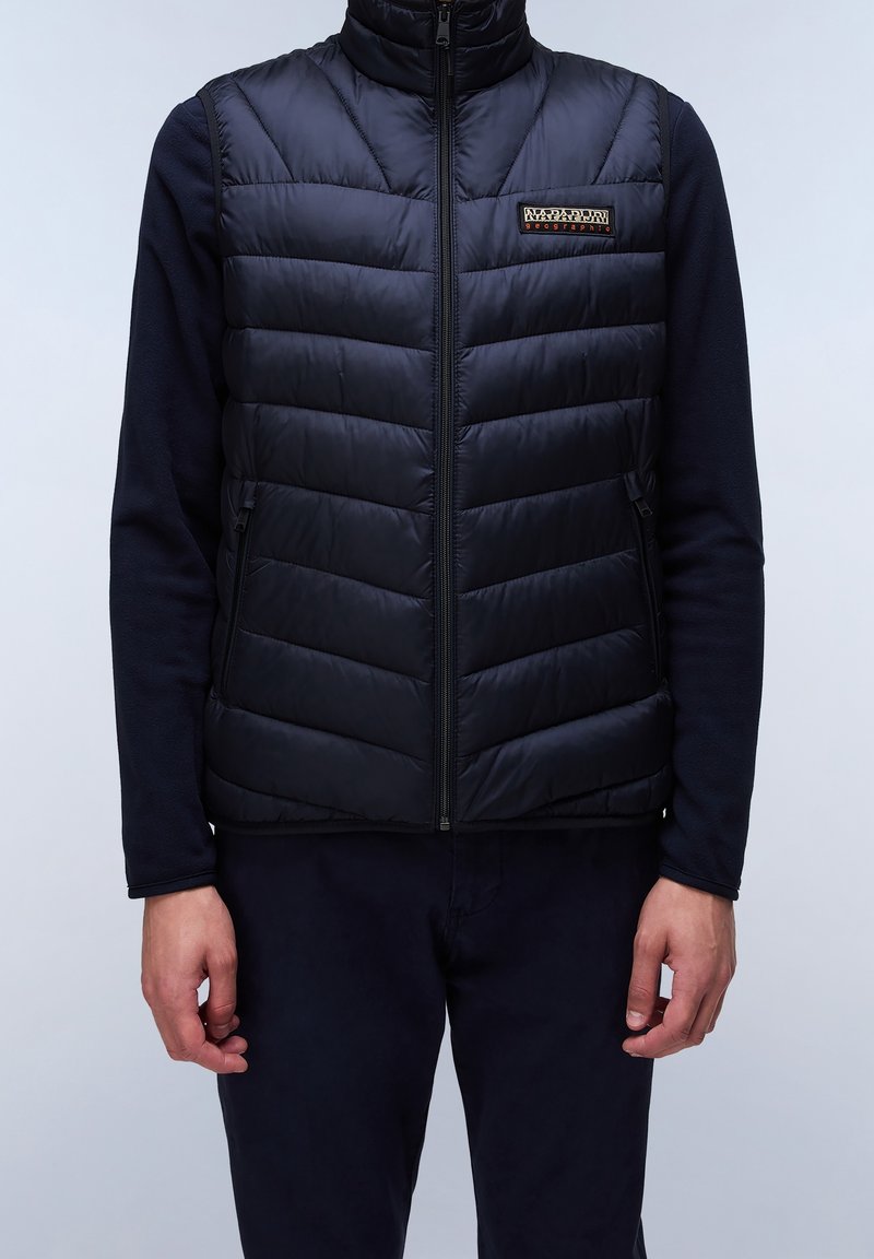 Marineblaue ärmellose Steppweste mit horizontal gequiltem Design, hohem Kragen und Frontreißverschluss. Mit einem kleinen Logoetikett auf der linken Brust.