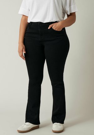 Zwarte denim flared jeans met een voorzak, hoge taille en een gladde, iets rekbare textuur, gecombineerd met witte sportschoenen.