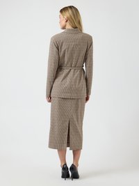 Pruun ruuduline ülikond vöökohaga ja pikkade varrukatega. Seelikul on taga lõhik. Sobitatud mustade kontsakingadega.