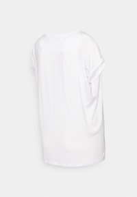 Camisa T-shirt branca de manga curta, material de algodão suave, ajuste solto, decote redondo, mangas com punhos dobrados e textura lisa com um design simples nas costas.