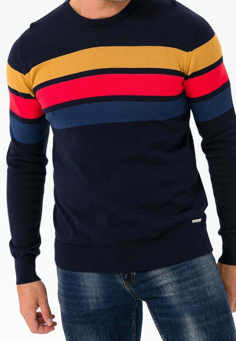 Pull bleu marine avec rayures horizontales multicolores en jaune, rouge, bleu foncé et bleu clair. Col et poignets côtelés, coupe ajustée.