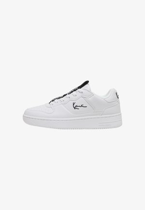 Baskets blanches basses avec doublure intérieure noire, logo de la marque noir sur le côté et le talon, et lacets blancs.