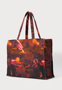 Τσάντα tote με ζωντανό λουλουδάτο μοτίβο σε σκούρο κόκκινο, πορτοκαλί και μαύρο χρώμα; φτιαγμένη από ύφασμα; διαθέτει δύο ανθεκτικούς ιμάντες και ευρύχωρο σχέδιο.