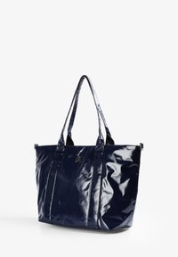 Bolso tote de charol azul marino con dos asas resistentes, que presenta una textura brillante y costuras verticales. Detalle de un pequeño logo como acento.