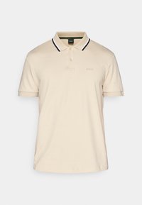 Beige poloko vyrobené z bavlny, s klasickým límečkem s černobílými pruhy, krátkými rukávy a malým logem na hrudi.