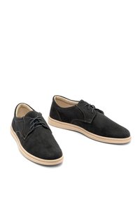 Scarpe in suede nere con texture perforata, punta rotonda, suola in gomma beige, lacci blu e cuciture a contrasto lungo le cuciture.
