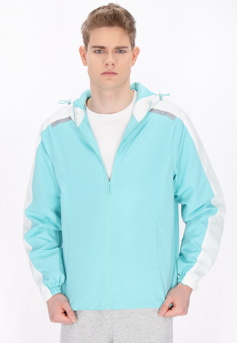 Giacca azzurra chiaro con cappuccio, dettagli bianchi sulle maniche, zip completa e polsini elasticizzati. Realizzata in un tessuto liscio e leggero.