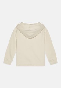Felpa beige con tasca frontale, cappuccio con cordino regolabile e polsini a costine. Tessuto morbido e testurizzato con vestibilità rilassata.