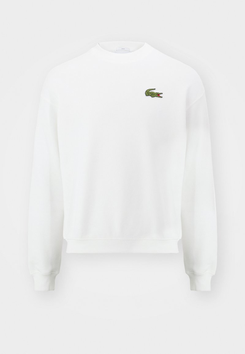 Sweat-shirt blanc col rond à manches longues avec un petit logo crocodile vert sur la poitrine gauche.