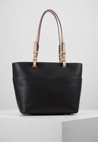 Musta nahkatote-laukku, jossa on ryhdikäs muotoilu, varustettuna vaaleanruskeilla säädettävillä olkahihnoilla ja hillityllä teksturoidulla pinnalla.