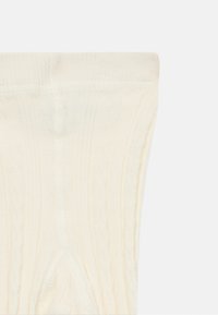 Kabelkované podkolenky v off-white barvě. Měkká textura, žebrovaný design a překlopený manžeta pro zvýraznění detailu.