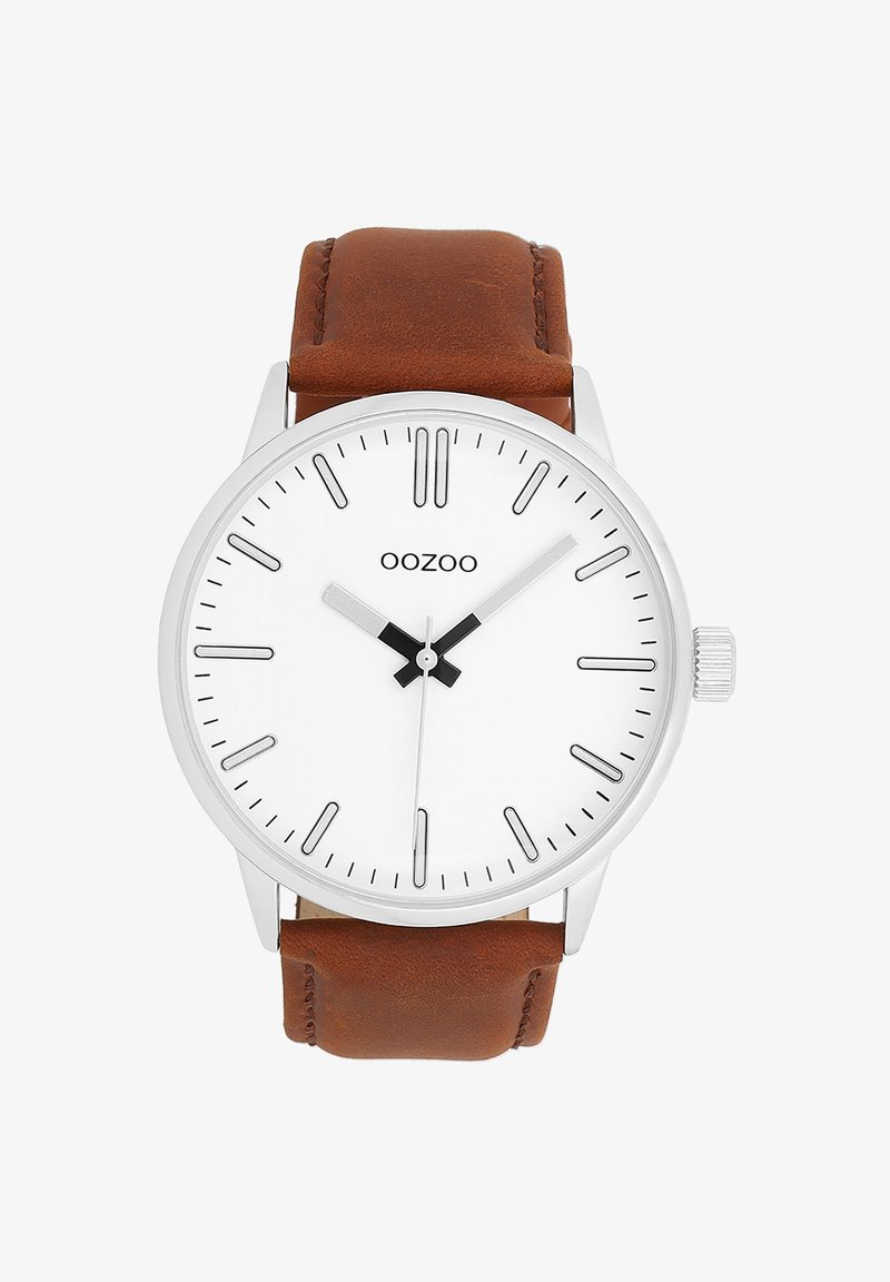 Montre argentée avec un cadran blanc, des index noir et des aiguilles. Bracelet en cuir marron avec une finition texturée. Nom de la marque "OOZOO" affiché.
