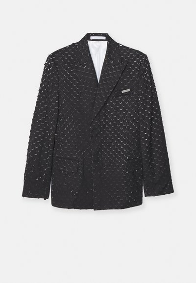 Black blazer with a textured surface featuring repeated crescent shapes, two side pockets, and a chest pocket. Lined interior.