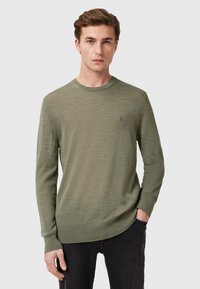 Olijfgroen gebreid sweater met lange mouwen, ronde halslijn, geribde manchetten en zoom, met een subtiele logo op de borst.