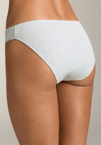 Bikini spodnjice iz svetlo modrega rebrastega materiala z gladko teksturo in nizkim pasom, ki nudijo minimalno pokritost ter brezšivno pasnico.