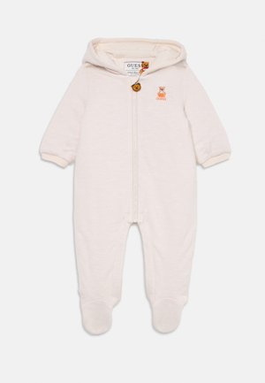 Krém színű overál, elöl cipzárral és kapucnival, bordás mandzsettákkal. Hímzett medve logóval és fa gomb részlettel rendelkezik. Puha tapintású.