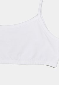 Vit bomullsbralette med tunna remmar och rundad halsringning. Har elastiskt kantband i nederkanten för en tät passform. Slät textur.