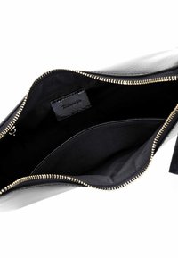 Zwarte leren handtas met een gladde textuur, voorzien van een gouden ritssluiting en een ruim interieur met een zwarte stoffen voering en label.