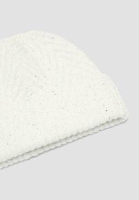 Weißer Strickbeanie mit gerippter Textur, der ein geometrisches Muster und kleine Pailletten für einen subtilen Glanz aufweist. An der umgeschlagenen Kante akzentuiert.