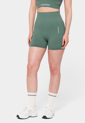 Roheline spordilühike, mis on valmistatud venivast materjalist, kõrge vöökoha, sileda tekstuuri ja väikese logoga esiküljel.