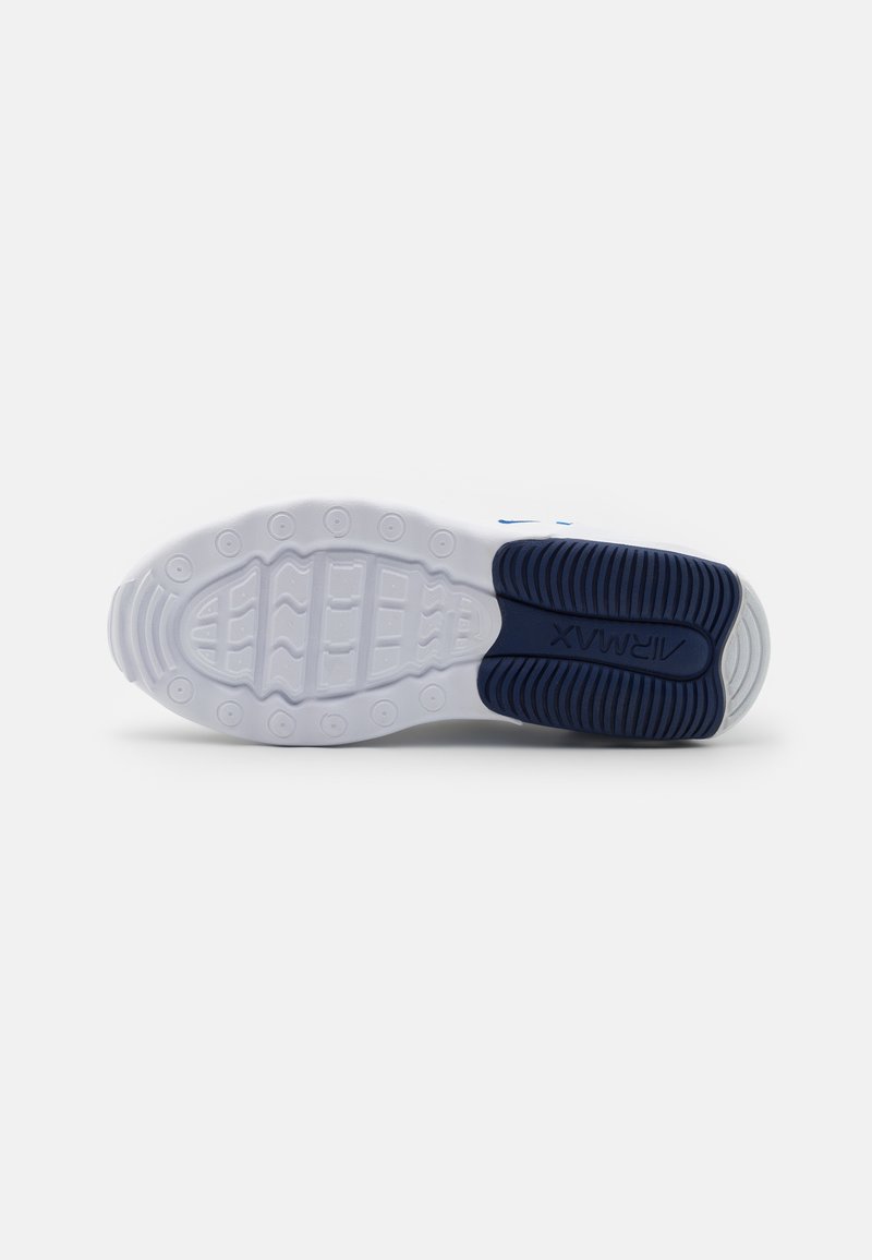 Suela de zapato deportivo blanca con una superficie texturizada y acentos azules, que presenta patrones de agarre circulares y la marca "Air Max".