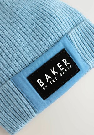 Blauer Strickbeanie mit gerippter Textur. Enthält ein rechteckiges schwarzes Etikett mit weißem Text "BAKER BY TED BAKER". Weicher Stoff, lässiges Design.