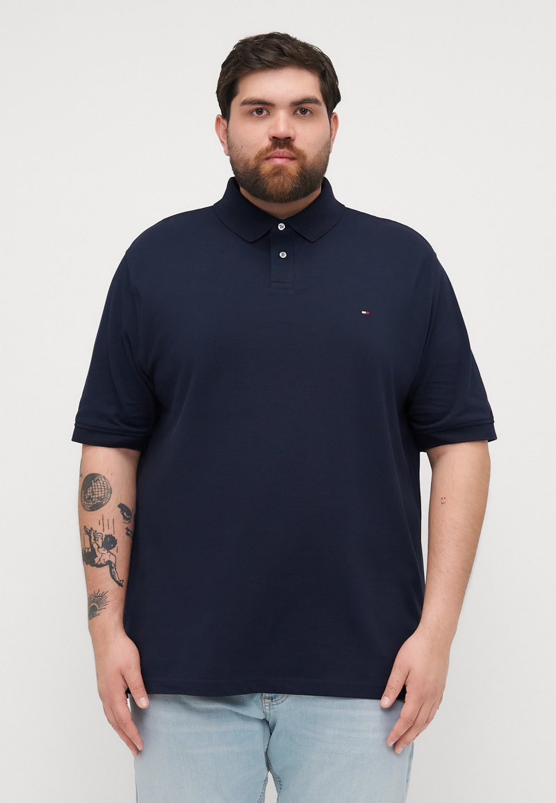 Navyblauwe poloshirt gemaakt van katoen, met een kraag, een twee-knopen sluiting en een klein logo op de linkerborst. Zachte textuur en korte mouwen.