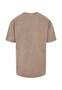 Khaki t-shirt med rund hals, korte ærmer og en tekstureret stof. Har et falmet, slidt udseende med synlige syninger.