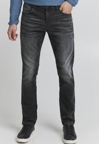 Mustad denim püksid slim fit lõikega, millel on veidi kulumist ja kulumise jälgi ees, tikandiga detailid ja viie tasku disain.