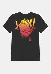 Camiseta de algodón negra con un gráfico en degradado audaz de un puño en alto en tonos naranja y amarillo. Diseño de manga corta y cuello redondo.