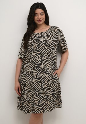 Abito a maniche corte color beige con strisce astratte zebra nere, caratterizzato da una vestibilità comoda e tasche laterali. Tessuto morbido e leggero.