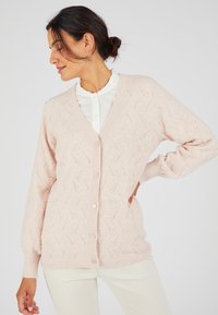 Cardigan lavorato a maglia rosa chiaro con scollo a V, cinque bottoni e motivo a foglia testurizzato; presenta polsini e orlo a costine per un tocco in più.