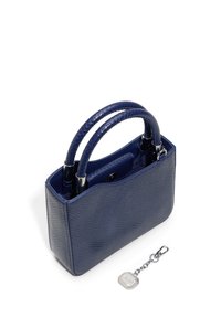 Marineblaue Handtasche mit strukturiertem Finish, zwei geflochtenen Griffen und einem kleinen silbernen Anhänger. Das Design ist strukturiert und kastenförmig.