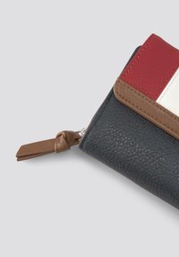 Portafoglio in pelle con materiale testurizzato nero e accenti rossi, bianchi e marroni, chiusura a zip e un cordino annodato marrone.