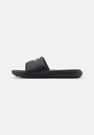 Sandale slide noire avec semelle rembourrée et large bride présentant un logo blanc, montrée de profil sur un fond uni.