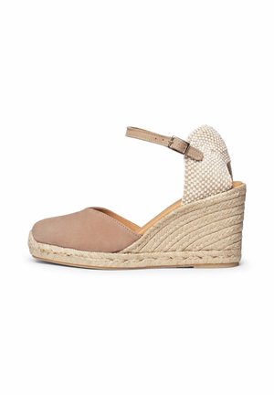 Alpargata cuña beige con puntera cerrada, correa ajustable al tobillo con hebilla, contrafuerte tejido en el talón y suela plataforma trenzada de yute.